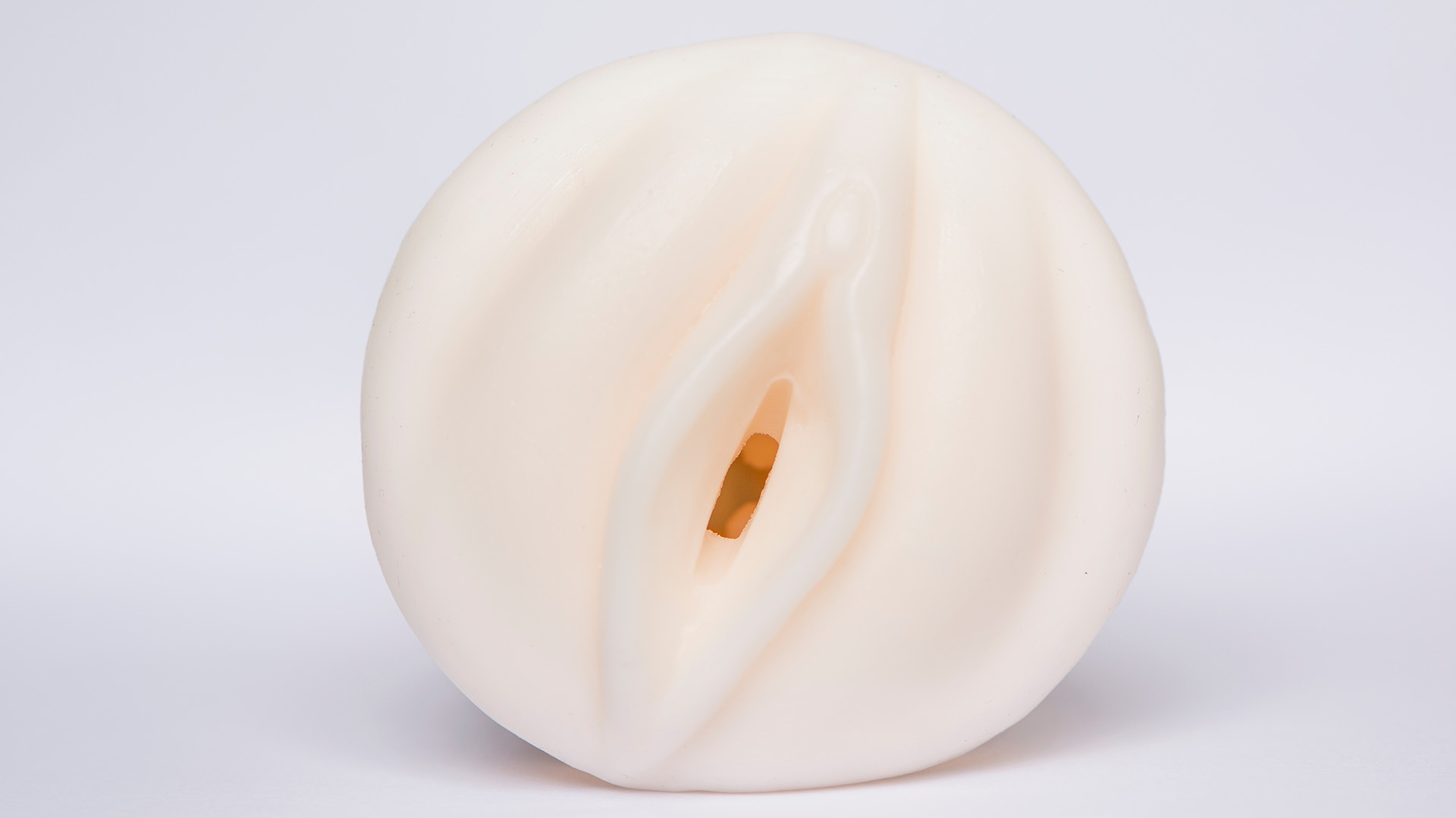 Beige fleshlight sex toy view from above in front of while background.