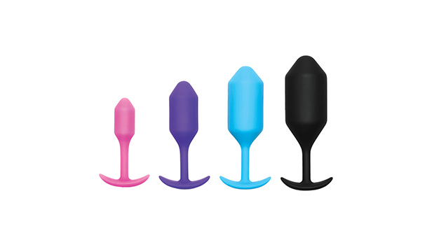 The B vibe butt plug in four sizes and colors: pink, purple, blue, and black. The toys are displayed on a white background.