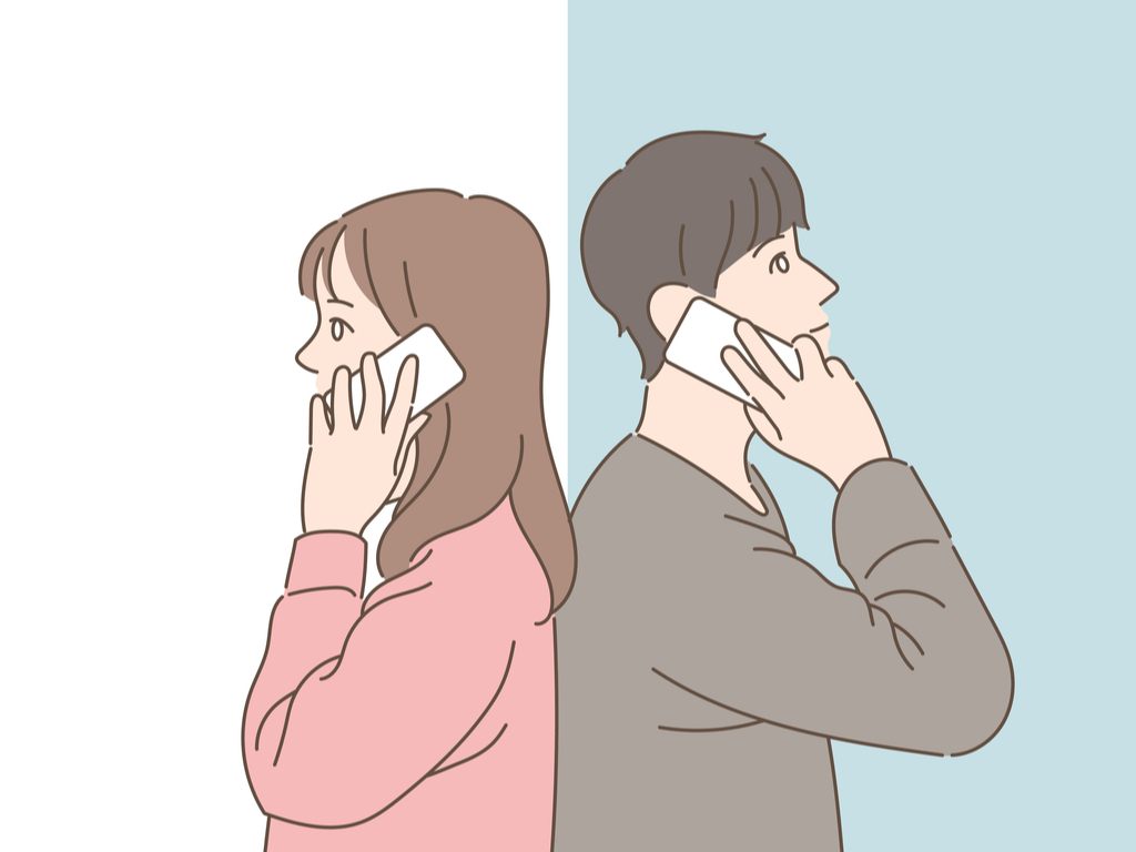 Man with grey shirt and woman with pink shirt standing back to back with each other whilst talking on the phone.